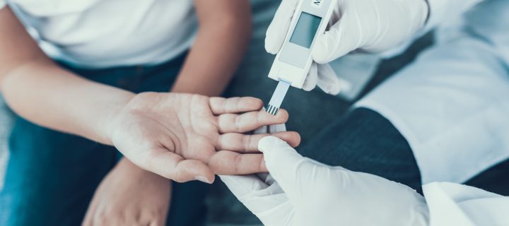 Doctor Taking Blood Sample from Boy's Finger. Diabetes Concept. Sugar in Blood. Healthcare Concept. Young Man in Uniform. White Coat. Medical Equipment. Boy in Clinic. Glucometer in Hand.